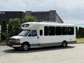 A white 2017 Chevrolet Express bus with large windows and a front-mounted air conditioning unit is parked on a paved surface.