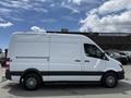 A 2016 Mercedes-Benz Sprinter van in white with a gray stripe on the side and multi-spoke wheels
