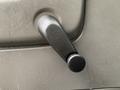 The interior door handle of a 2015 Chevrolet Express featuring a black manual window crank with a textured surface