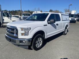 A white 2017 Ford F-150 with a truck bed cover parked in a lot showcasing its sleek design and chrome grille