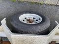 A 2014 Express 8 Foot Trailer features a steel wheel with a metallic rim and a black tire showing visible tread patterns and some surface rust on the lug nuts