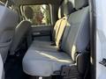 The image shows the interior backseat of a 2014 Ford F-550 with grey fabric upholstery and seating for three passengers
