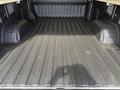 The image shows the bed of a 2019 Chevrolet Silverado 1500 with a textured black surface and two wheel wells protruding from the sides