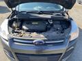 The engine compartment of a 2016 Ford Escape with the hood raised showing the engine and various components