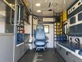 Interior view of a 2011 Chevrolet Express with a single driver's seat a medical equipment area and storage compartments