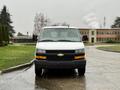 A white 2021 Chevrolet Express van is parked with its front facing the viewer showcasing its black grille and Chevrolet logo