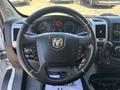 Steering wheel of a 2020 RAM ProMaster 3500 featuring the RAM logo controls for audio and cruise settings displayed on the dashboard behind it