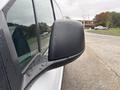 Side mirror of a 2019 Ford Transit Connect with raindrops on its surface