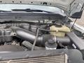 The engine compartment of a 2014 Ford F-350 SD featuring various components such as the air intake hose coolant reservoir and other engine parts