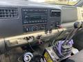 Dashboard of a 2002 Ford F-550 showing the radio controls gear shifter and interior accessories