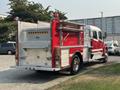 A red 1999 Freightliner FL80 fire truck with shiny metal details and emergency lights mounted on top