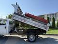 A 2008 Ford F-450 SD with a dump bed raised, displaying the truck's side and rear dump features