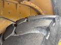 Close-up of a rugged tire from a 2012 Caterpillar 980 showcasing deep treads and wear marks on the surface