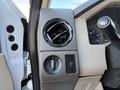 The interior controls of a 2009 Ford F-550 including an air vent a dial for air control and various switches on a textured panel