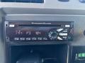 A car stereo with a digital display and buttons labeled for navigation and sound control
