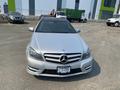 A 2013 Mercedes-Benz C-Class in silver color with a black grille and emblem is parked in the foreground