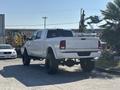 A 2018 RAM 3500 truck in white with a lifted suspension and large black tires parked in a lot