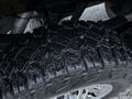 Close-up of a textured tire with deep treads from a 2017 GMC Sierra 3500HD showing signs of moisture on the surface