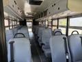 Interior view of a 2009 International 3000 CE school bus featuring rows of gray seats with seat belts and a central aisle running through the length of the bus