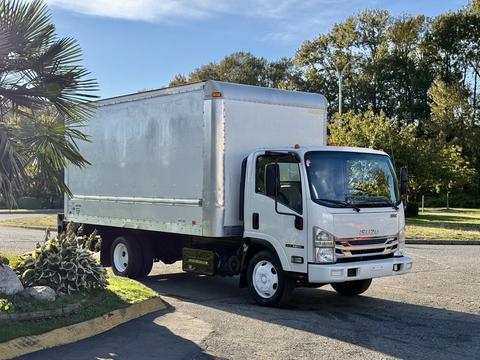 A 2016 Isuzu NRR box truck with a silver cargo area and white cab parked on a driveway