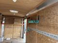 Interior of a 2016 Continental cargo trailer featuring wooden walls shelves and mounted green storage tubes along the side