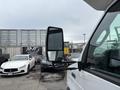 A 2014 Ford E-350 van with a side mirror prominently displayed