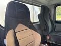 Two dark fabric seats in a 2008 Peterbilt 340 truck cabin with visible stitching and the Peterbilt logo on the back of each seat
