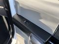 Close-up of a 2020 Ford F-350 door panel featuring a power window control button in a light and dark color scheme