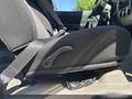A close-up view of the driver's seat in a 2011 Chevrolet Colorado with a seatbelt fastened and a lever for adjusting the seat position