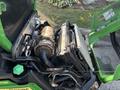 Close-up of the engine compartment of a 2021 John Deere 1575 featuring an engine, battery, and various mechanical components visible inside the open hood