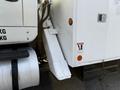 A 2011 International 7500 truck with a white body and dark accents showcasing the truck's side and step area