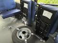 A 2020 Chevrolet Express with two blue folding seats and a spare tire secured with metal straps on the floor