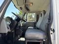Interior view of a 2011 International 4300 featuring a driver's seat and passenger seats with a gray color scheme and a steering wheel visible