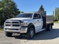 A 2014 RAM 5500 pickup truck with a flatbed in a white color with chrome accents and black side panels