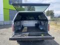A 2014 Ford F-150 with its tailgate down and a bed cap open showing the truck bed's interior features and lining