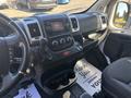 Interior dashboard view of a 2020 RAM ProMaster 3500 with controls for audio and climate settings along with a gear shifter and cup holders visible
