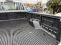 A 2008 Ford F-250 SD truck bed with a textured black liner and a storage compartment on the side