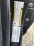 A 2015 Dodge Charger door frame displaying various vehicle identification and safety labels