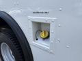 A fuel cap access point labeled Unleaded Fuel Only on a 2018 Ford Econoline with a yellow cap attached by a tether