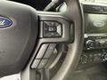 Close-up of the steering wheel controls of a 2020 Ford F-550 featuring audio volume buttons and phone controls