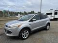 A silver 2015 Ford Escape parked with its driver side facing forward showcasing its compact SUV design and alloy wheels