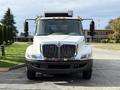 A 2012 International 4300 truck facing forward with a white body and chrome grille headlights on either side
