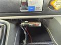 A close-up view of a toggle switch for a CURT TriFlex brake controller mounted on a dashboard with visible wiring and labels