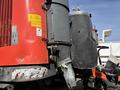 A 2018 Sandvik Ranger DX800 with red and gray components featuring a cylindrical attachment and warning labels on its side