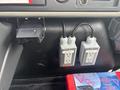 Close-up of the dashboard of a 2012 International 7300 Workstar featuring two 120 volt electrical outlets and a mounted device holder
