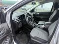 Interior view of a 2014 Ford Escape featuring a dashboard with gauges a steering wheel and two front seats with fabric upholstery
