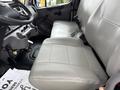 The image shows the driver's side interior of a 2021 Freightliner M2 106 featuring a gray leather seat and a dashboard with controls and a gear shifter