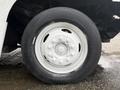 A close-up of a white wheel with a silver hubcap from a 2018 Ford E-450 featuring a black tire with visible tread patterns