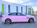 A pink 2020 Jaguar XE with sleek lines and alloy wheels is prominently displayed in profile view