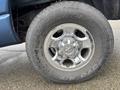 Close-up of a chrome wheel rim on a 2006 Dodge Ram 2500 with a Toyo H/T tire showing visible tread pattern and signs of wear